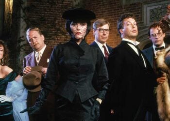 The cast of Clue (1985) posed outside the mansion — Miss Scarlet, Mrs Peacock, Mr Green, Professor Plum, Colonel Mustard and Mrs White