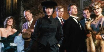 The cast of Clue (1985) posed outside the mansion — Miss Scarlet, Mrs Peacock, Mr Green, Professor Plum, Colonel Mustard and Mrs White