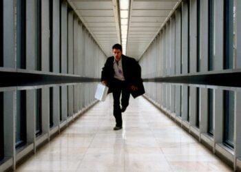 Colin Farrell running through a glass corridor in The Recruit (2003)