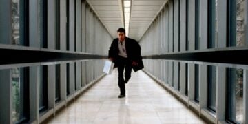 Colin Farrell running through a glass corridor in The Recruit (2003)
