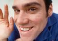Jim Carrey as Chip Douglas grinning and waving at close range in The Cable Guy (1996)