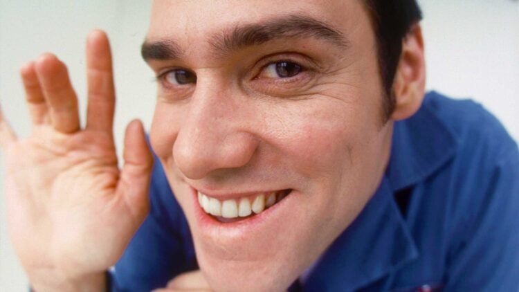 Jim Carrey as Chip Douglas grinning and waving at close range in The Cable Guy (1996)