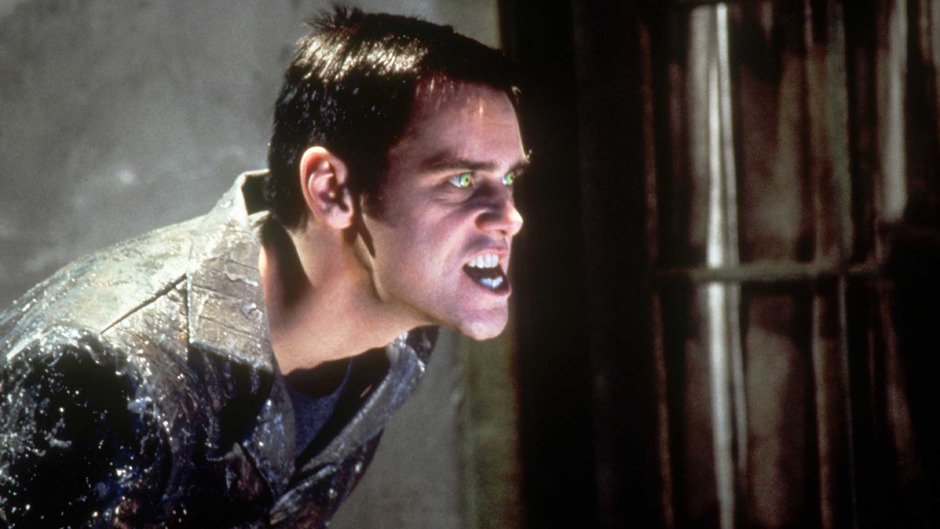 Jim Carrey as Chip Douglas soaking wet with glowing green eyes in a menacing close-up from The Cable Guy (1996)