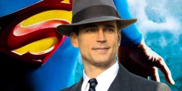 Matt Bomer in a suit and fedora in front of the Superman logo