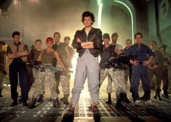 Sigourney Weaver as Ripley with the Colonial Marines squad in a promotional photo for Aliens (1986)