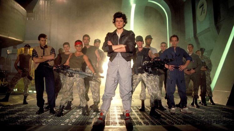 Sigourney Weaver as Ripley with the Colonial Marines squad in a promotional photo for Aliens (1986)