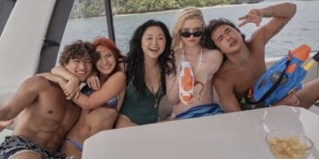 Kathryn Newton, Lana Condor, and castmates smiling together on a boat in The Devil's Mouth