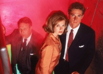Three Dark Skies cast members in a tense stairwell scene lit in red and green