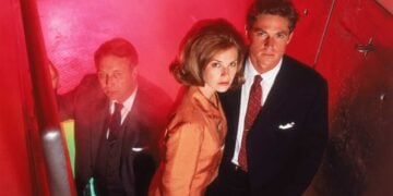 Three Dark Skies cast members in a tense stairwell scene lit in red and green