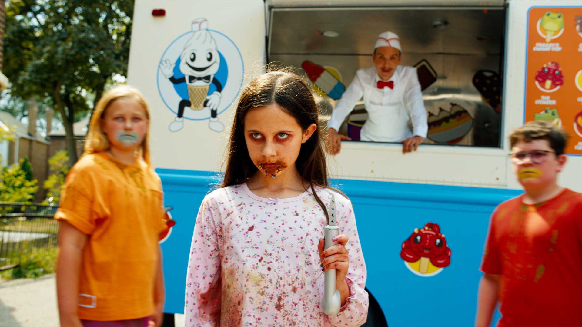 Blood-stained children stand near the Ice Cream Man's truck as he watches from the window