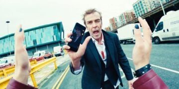 Karl Davis showing his phone in Bad Day at the Office